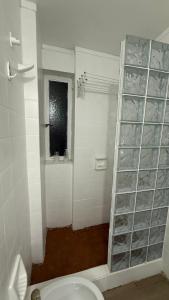 a bathroom with a toilet and a shelf of glasses at Monoambiente Viamonte in Buenos Aires
