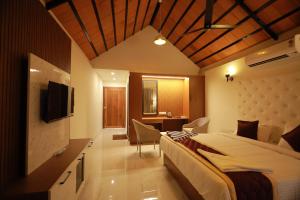 a hotel room with a bed and a television at Dee Cottage kanyakumari in Kanyakumari