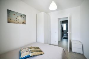 a white bedroom with a bed and a painting on the wall at Villa Gioia con piscina privata in Marina di Ragusa +33 photos