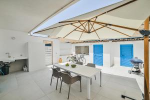 a dining room with a white table and chairs at Villa Gioia con piscina privata in Marina di Ragusa