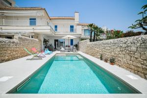 a swimming pool in front of a house at Villa Gioia con piscina privata in Marina di Ragusa
