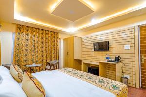 a hotel room with a bed and a desk at Hotel Peak Paradise Resorts in Pahalgām