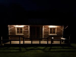a wooden cabin with lights in the dark at The Sunset Cabin in Beccles