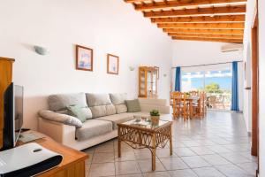 a living room with a couch and a table at Villa Maru I by Villa Plus in Cala en Porter