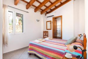 a bedroom with a bed and a window at Villa Maru I by Villa Plus in Cala en Porter
