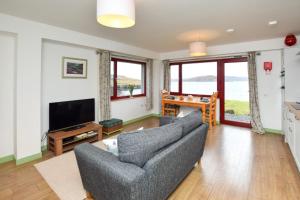 a living room with a couch and a television at 1 Bed in Reef oc-r30134 in Uig