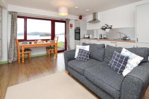 a living room with a gray couch and a kitchen at 1 Bed in Reef oc-r30134 in Uig