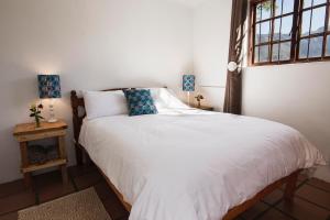 a bedroom with a white bed and a window at Hermitage Huisies in Swellendam +85 photos