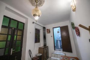 a hallway with a door and a chandelier at Guest House Jnan Sbil in Fez