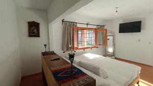 a bedroom with a bed and a television on the wall at Popo Country House in Atlautla