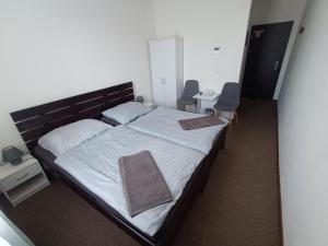a bedroom with a large bed and two chairs at Apartmány ARIES in Nitra