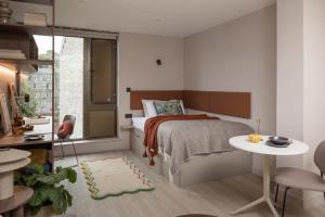 a small bedroom with a bed and a table at The Pepper Mill - Campus Residence in Edinburgh