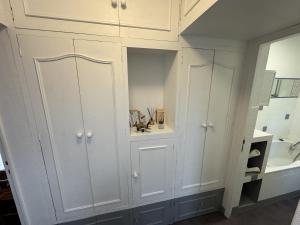 a bathroom with white cabinets and a mirror at Maison paisible à Senlis in Senlis +6 photos