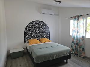a bedroom with a bed with a black and white headboard at Villa Capucine in Saint-Paul +31 photos