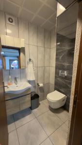 a bathroom with a toilet and a sink at Sarıyer Otel in Ula