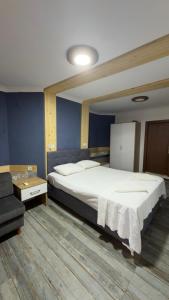 a bedroom with a large bed and a chair at Sarıyer Otel in Ula
