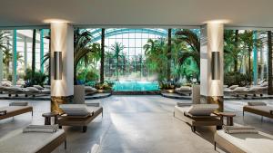 a hotel lobby with a pool and palm trees at Sinnada Resort & Thermaland in Afyon