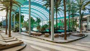 a large building with palm trees and lounge chairs at Sinnada Resort & Thermaland in Afyon