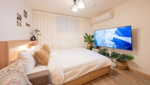 a bedroom with a bed and a tv on the wall at STR Stay Bangbae in Seoul