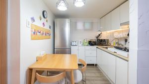 a kitchen with a wooden table and a refrigerator at STR Stay Bangbae in Seoul