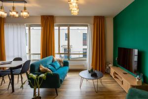 a living room with a blue couch and a green wall at Lakeside Lugano in Lugano