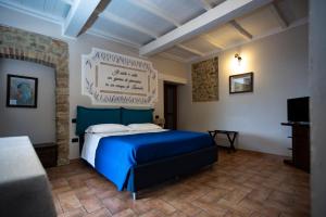 a bedroom with a blue bed and a television at La Tenuta dei Fiori in Ferentillo +50 photos