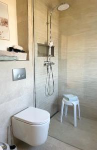 a bathroom with a shower and a toilet and a stool at Apartments Aura & Nova in Aue-Bad Schlema +33 photos