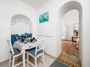 a dining room with a white table and chairs at A la casa del cavaliere in Positano +29 photos