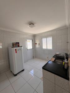 an empty kitchen with a refrigerator in a room at Casa Freire in Maceió