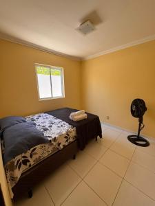 a bedroom with a bed and a fan and a window at Casa Freire in Maceió