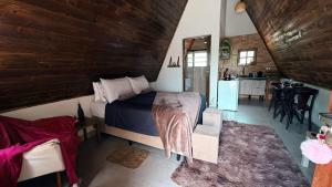 a bedroom with a large bed and a kitchen at Elshadaychale in Ibiúna