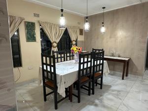 a dining room table and chairs with a vase of flowers at Cactus Village in Blantyre