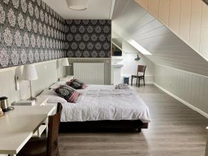 a bedroom with a large bed and a staircase at B&B Castellier in Lier