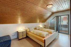 a bedroom with a large bed with a wooden ceiling at Ferienwohnung Ettenheim in Ettenheim