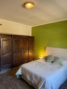 a bedroom with a bed with a green wall at Casa 2 hab, cerca del centro y costanera in Gualeguaychú