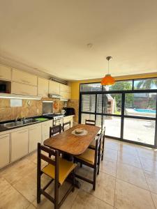 a kitchen with a wooden table and some chairs at Casa 2 hab, cerca del centro y costanera in Gualeguaychú