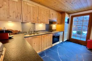a kitchen with wooden cabinets and a blue floor at Eclat de Soleil 023 in Verbier
