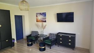 a room with two chairs and a dresser and a tv at W Ustce Lipa in Ustka