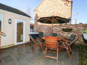 a patio with a table and chairs and an umbrella at Old Post Office in York