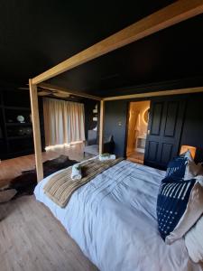 a large bed in a room with a large bed sidx sidx sidx at Forest Nature Spa in Plettenberg Bay