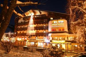 a building with a christmas tree in front of it at Berger's Sporthotel in Saalbach-Hinterglemm
