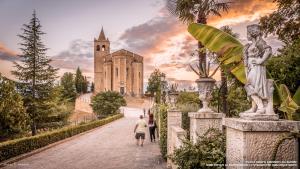 a man walking down a path in front of a building at Agriturismo San Filippo Neri in Castignano