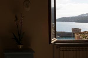 a window with a view of a body of water at Tra Tetti e Mare - HelloElba in Portoferraio +39 photos