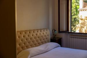 a bed in a bedroom with a window and a mattress at Tra Tetti e Mare - HelloElba in Portoferraio