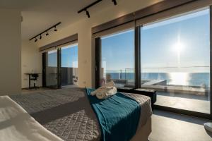 a bedroom with a bed with a view of the ocean at Sun and Sea Apartment - Beachfront, 2 Bedrooms with Sea View & Garden in Paralio Astros