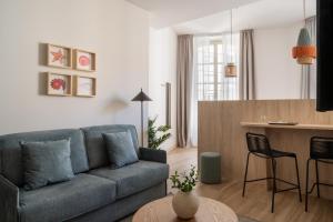 a living room with a couch and a table at Líbere Málaga Plaza del Siglo in Málaga