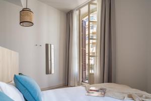 a bedroom with a bed and a window at Líbere Málaga Plaza del Siglo in Málaga
