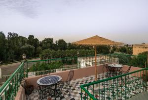 a balcony with tables and chairs and an umbrella at Guest House Jnan Sbil in Fez