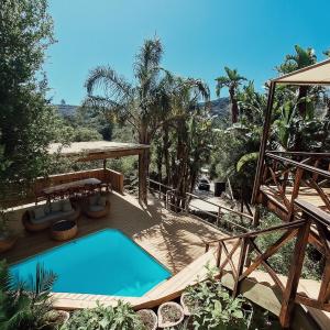 a swimming pool on a deck with a table and a table at Forest Nature Spa in Plettenberg Bay +8 photos