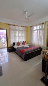 a bedroom with a large bed in a room with windows at Mayabini Homestay 3BHK in Guwahati